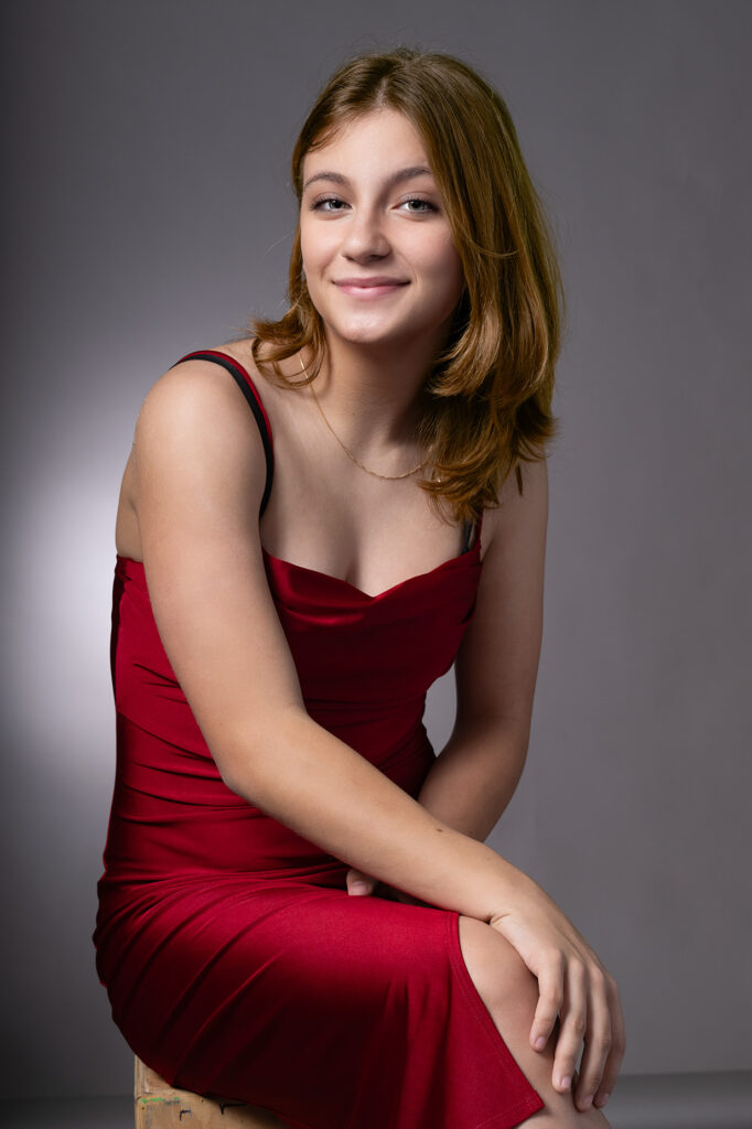 photo headshot of teen girl in red dress in front of a gray background - la headshot photographer