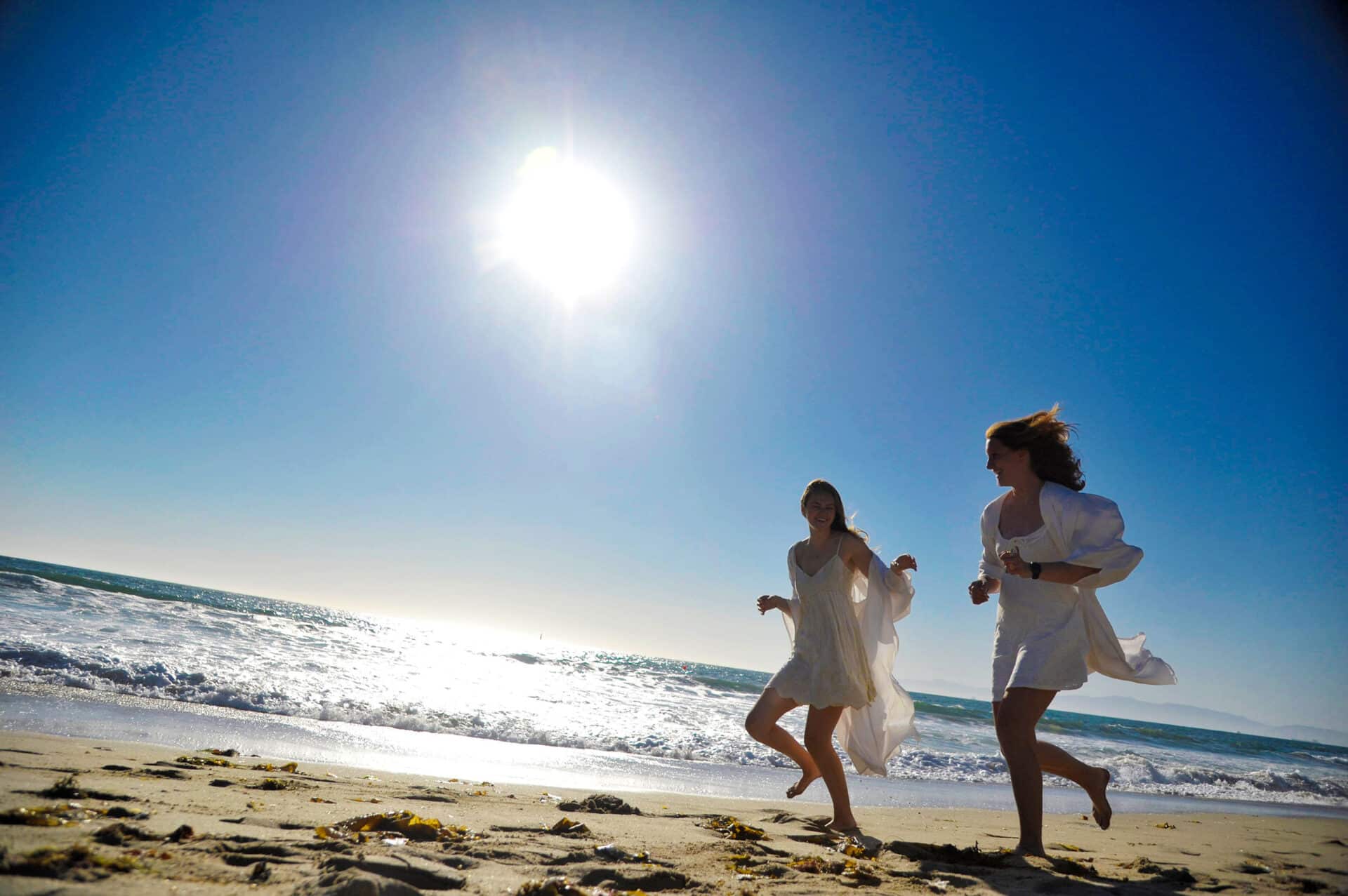 Graduation photographer shoots beach lifestyle graduate photos of two best girl friends.